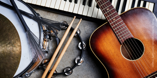 A group of musical instruments including a guitar, a drum, a keyboard and a tambourine