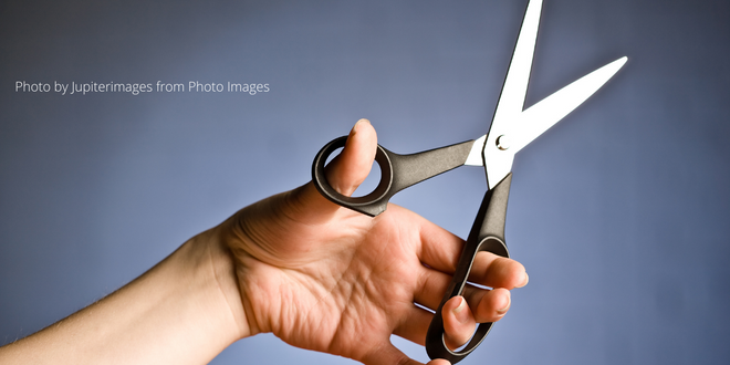 A hand holding a pair of scissors