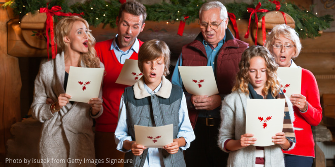 Children, parents and grandparents singing Christmas carols together