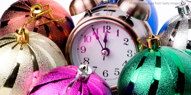 An alarm clock surrounded by colourful Christmas baubles