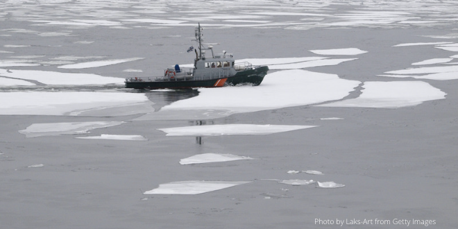 A boat sailing on a stretch of water full of ice floats