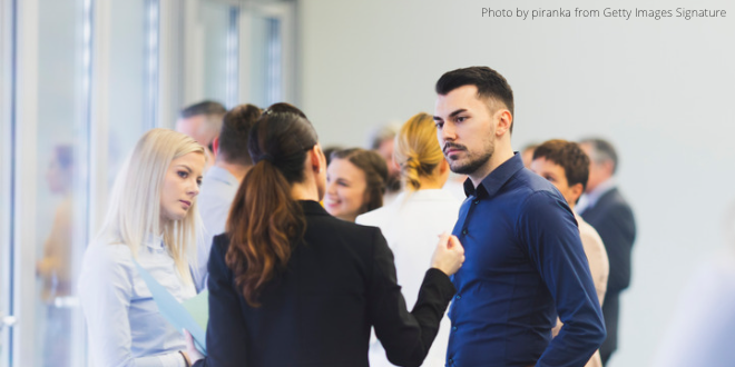 A group of people standing together and talking to each other