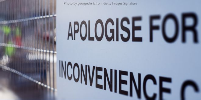 A close-up of a text on a building site: Apologise f or the inconvenience