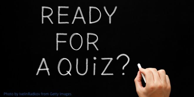 A hand holdling a piece of chalk with the words "Ready for a quiz?" on a blackboard