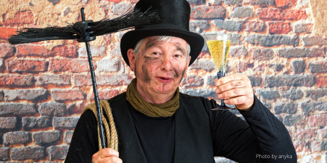 A chimney sweep holding a glass of champagne