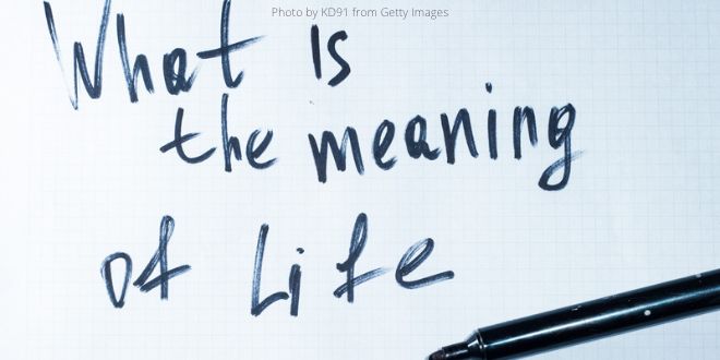 A white sheet of paper with the question "What is the meaning of life?" and a black pen in the right-hand corner