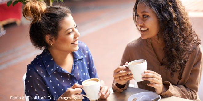 Two young ladies having a conversation over a cup of coffee