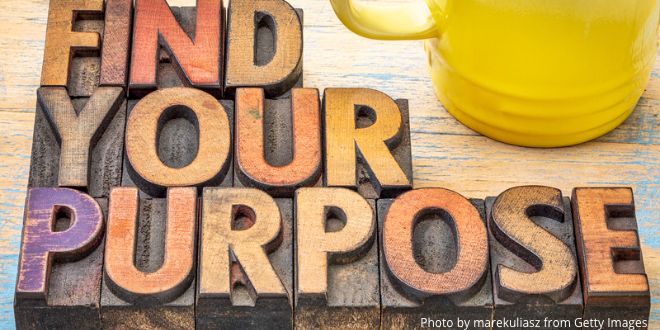 Wooden blocks with the letters "Find your purpose" and part of a yellow mug