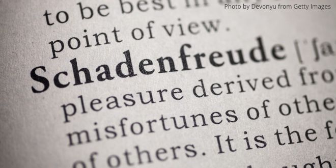 A close-up of a dictionary and the German word "Schadenfreude"