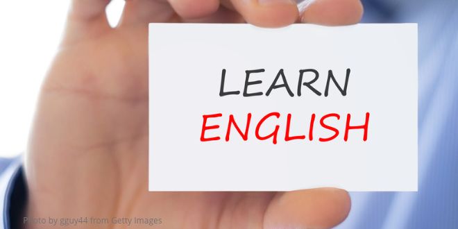 A hand holdling a card with the words "Learn English"