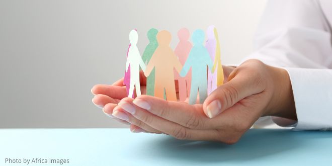 A woman's hands holding cut-out figures to show diversity and inclusion