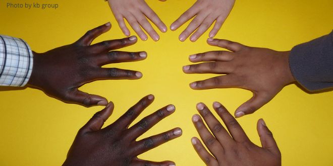 Three pairs of hands, one white, one brown and one black