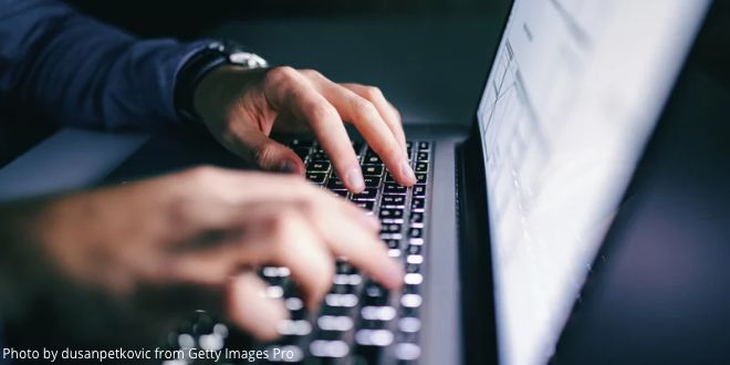 Male hands typing on a laptop