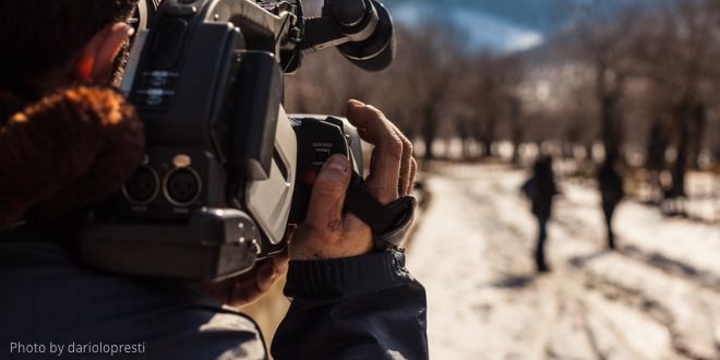 A cameraman filming people outside