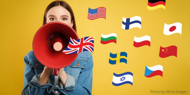 A woman talking through a megaphone with the Union Jack coming out of it, and surrounded by lots of different flags