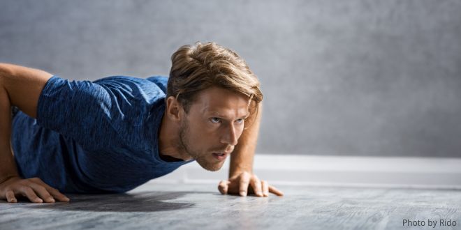 The power of one push-up A young man in a blue T-shirt doing a push-up