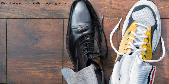 An elegant black leather shoe and a running shoe