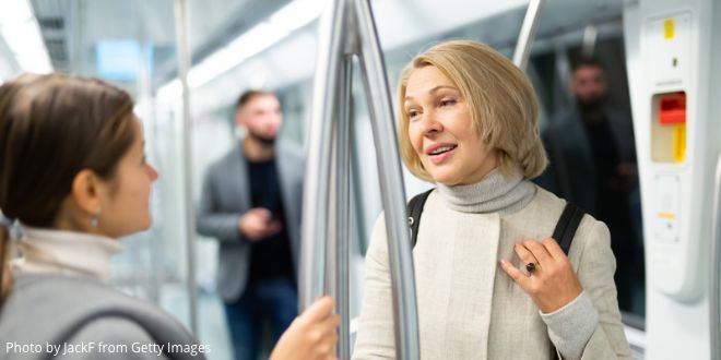 Two women talking to each other on the underground