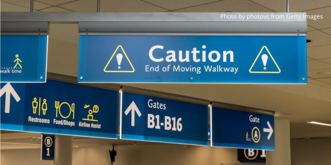 Signs at an airport-One with "Caution End of Moving Walkway"