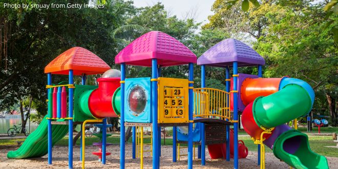 A children's playground with plastic climbing frames, slides etc.