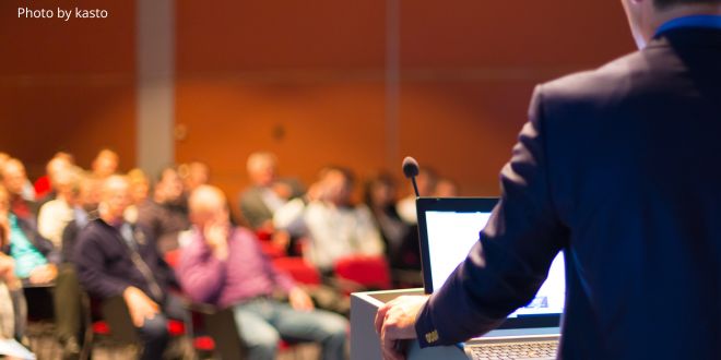 A man presenting in front of an audience