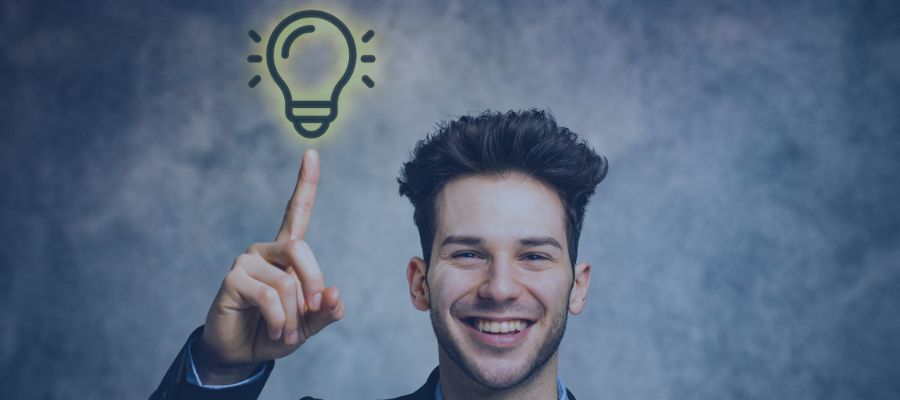 Englische Grammatik verständlich erklärt A man smiling, with his hand pointing to a light bulb in the air