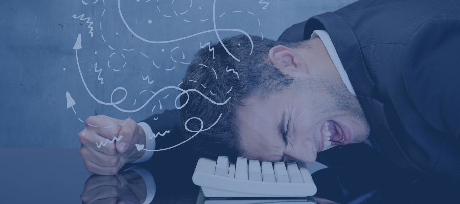 Frustrated man with head on keyboard Frustrated man with his head on the keyboard and his fist on the table