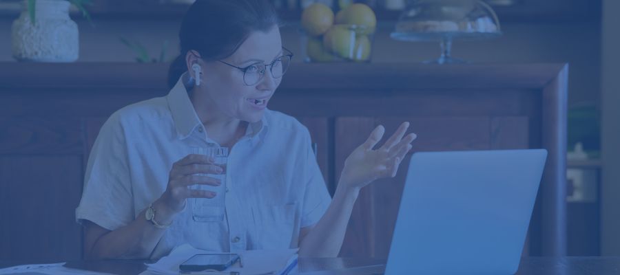 A woman talking in front of her laptop